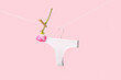 Female panties and rose flower hanging on rope against pink background
