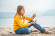 © velirina - Lonely beautiful sad girl teenager sits thoughtfully on sand sea beach. Dreams,anxiety,worries about future,school friends, parents. Teen bullying, psychological problems in adolescent puberty period