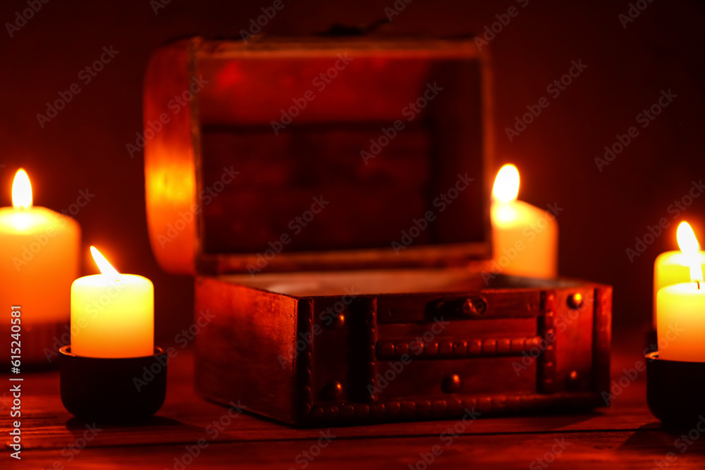 Decorative box with burning candles on dark background