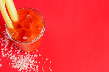 Fototapeta glass of bloody mary with celery and salt on red background