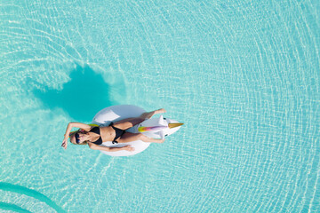 Wall Mural - Top view of beautiful woman relaxing in swimming pool