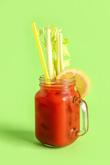 Poster - Mason jar of bloody mary with celery and lemon on green background