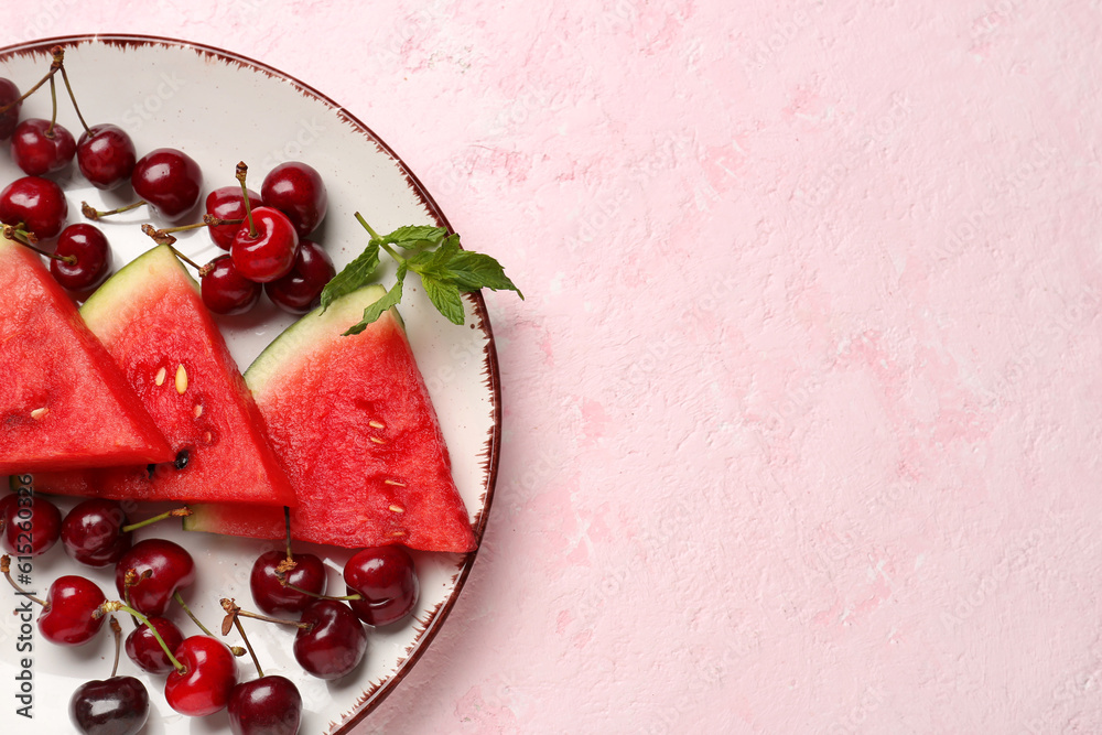 Pieces of fresh watermelon and cherries on pink background