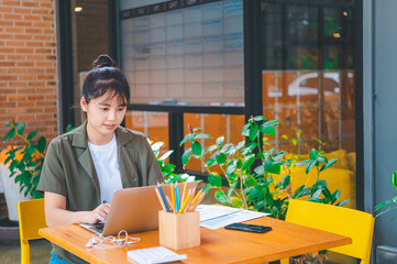 Wall Mural - Freelance worker working on documents with graphs. and information about finances on laptops in cafes