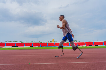 Wall Mural - Dedicated Asian speed runner, equipped with two prosthetic running blades, jogging steadily on the running track at the local sports stadium