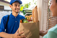 Asian Young Delivery Man Delivering Package To Female Customer At Home. 