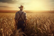 © Cheport - A farmer in the field of wheat at sunset. Rear view, unrecognisable person