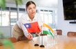 © JackF - Woman secretary prepares an office for negotiations - she places flags of Taiwan and India the table