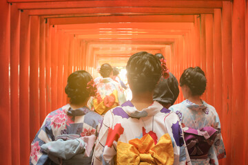 Three japanese girls in kimono walking the Fushimi Inari-Taisha gates