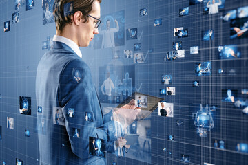 Wall Mural - Attractive european businessman using pad with connecting businesspeople, technology, metaverse and video conference concept. Creative images connected on blurry blue background.