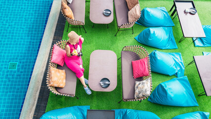 Top view traveler woman in pink dress relaxing on chair at outdoor cafe restaurant, Attraction famous popular place tourist travel Pattaya Thailand vacation summer holiday, Beautiful destination Asia