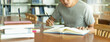 Leinwandbild Motiv male asian student studying and reading book in library
