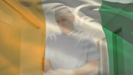 Poster - Animation of flag of ivory coast, caucasian surgeon adjusting gloves and rushing to operation room