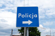 © Longfin Media - Police information road sign in Poland, indicating the location of a police station. Letters in Polish language, Policja means Police.