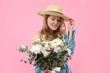 © New Africa - Beautiful woman in straw hat with bouquet of flowers on pink background