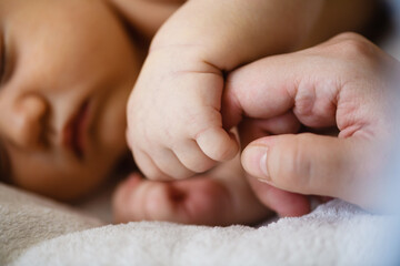 close up baby hand catch mom finger