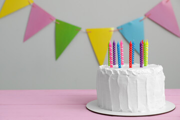 Wall Mural - Delicious cake with cream and candles on pink wooden table. Space for text