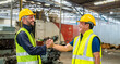 © BESTIMAGE - greeting by handshake touch fist and elbow of two engineer supervisor partnership in old factory. foreman greeting friend for good friendship colleague laborer in teamwork factory.