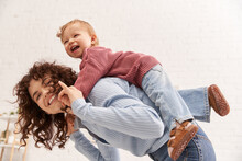 Quality Time, Happiness, Balancing Between Work And Life, Cheerful Woman With Excited Baby Girl On Back, Mom Daughter Time, Having Fun Together, Bonding, Loving Motherhood, Curly Hair