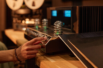 Closeup of male hand switching on retro record player, copy space