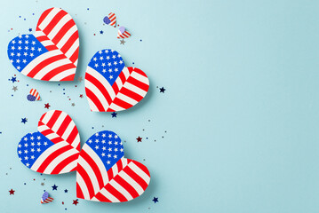 Wall Mural - USA freedom commemorations. Overhead shot of iconic embellishments: hearts featuring American flag motif, confetti, arranged on pastel blue surface with space ideal for text or promotional content