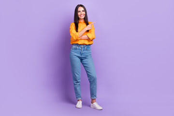 Sticker - Full length photo of gorgeous girl dressed yellow shirt denim pants indicating at discount empty space isolated on purple color background