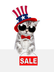Poster - Cute kitten wearing like Uncle Sam looks from behinde empty white banner and shows signboard with labeled 