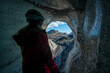 © Designpics - View through an ice cave of a woman exploring a glacier while traveling in Iceland; Vik, South Iceland, Iceland