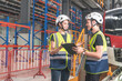 © supAVADEE BUTRADEE - Female engineer and male technician, maintenance work team in uniform and safety helmet holding tablet looking at electric train repair checklist in electric train control station.