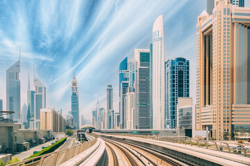 Wall Mural - Metro road among glass skyscrapers in Dubai. Metropolitan railway among glass skyscrapers in Dubai. Traffic on street in Dubai. Modern with skyscrapers architecture of Dubai, UAE. Altered sky.