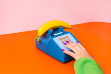Crop Woman Touching Toy Retro Table Phone With Banana