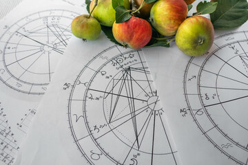 Wall Mural - Printed birth charts with small red apples in the background
