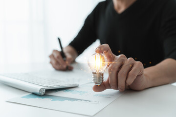 Wall Mural - Bright or glowing lightbulb. Businessman working with data and information. Success concept of business solution, planning and strategy or finance analysis.