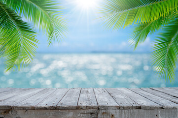 Canvas Print - Empty wood table with seascape and palm leaves, blur bokeh light