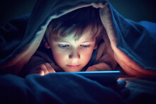 Small Boy Watching Tablet Or Mobile Phone At Bed, Blanket Over His Head, Close-up Detail To Face And Eyes. Bedtime Harmful Blue Light Screentime Concept. Generative AI