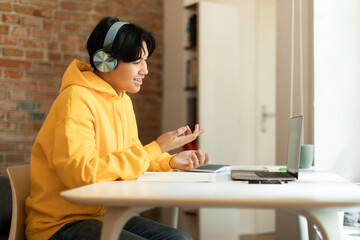 Wall Mural - Korean Student Boy Talking To Laptop During Remote Class Indoor