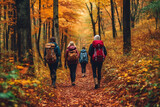 Couple with backpacks walking on path in autumn season forest