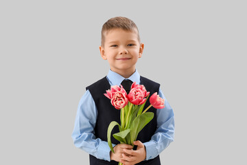 Canvas Print - Cute little boy in suit with tulips on grey background