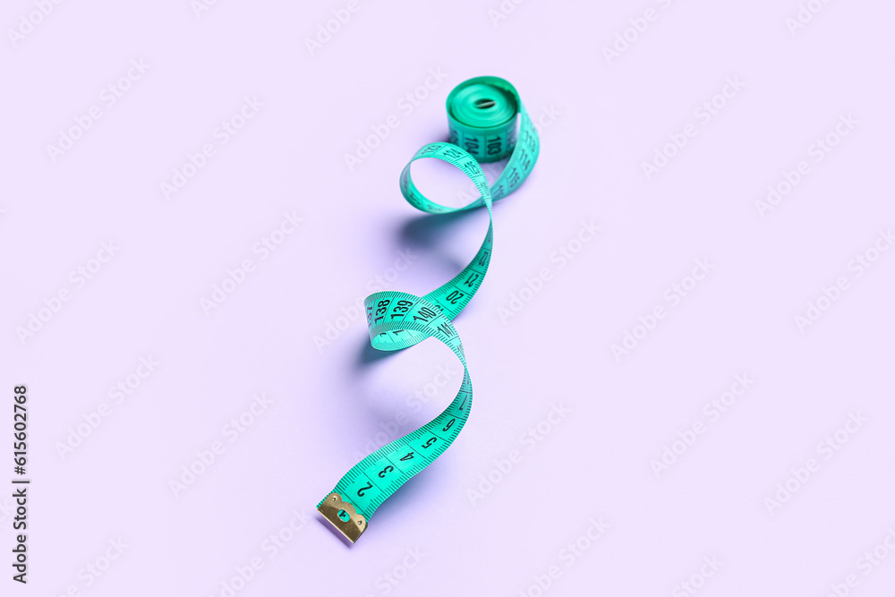 Measuring tape on lilac background