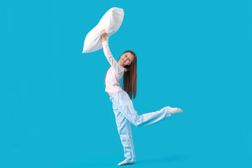 Wall Mural - Little girl playing with pillow on blue background