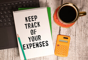 White card with the text Keep track of your expenses on wooden desk background. business concept.