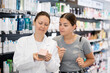 © JackF - Female pharmacist advises a woman visitor a good skin care remedy, standing in the sales hall of a pharmacy