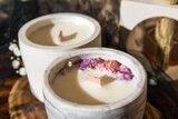 Fototapeta Tulipany - Holders with candles and flowers on table in room, closeup