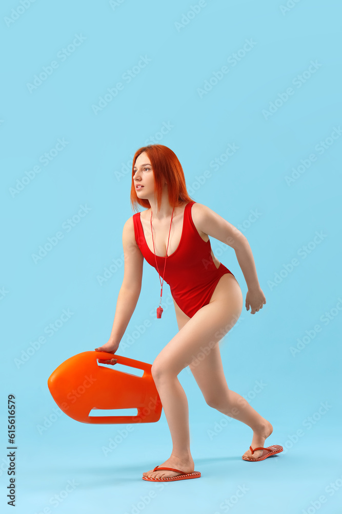 Female lifeguard with rescue buoy running on blue background