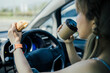 © littlepigpower - Asian woman eating food while drive car in the morning going to work.
