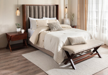 A cozy bedroom featuring a queen-sized bed placed next to a wooden table and a window