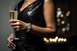 © Golib Tolibov - a woman holding a glass of champagne with sparkling lights in the background on her left arm and right arm,
