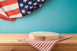 Empty wooden podium log with tablecloth on table over USA flag background. American national holiday mock up for design and product display