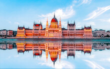 Parliament Building In Budapest With Fantastic Perfect Sky And Reflection In Water. Calm Danube River. Popular Travel Destinations.