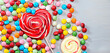 Photo colorful lollipops and different colored round candy. top view